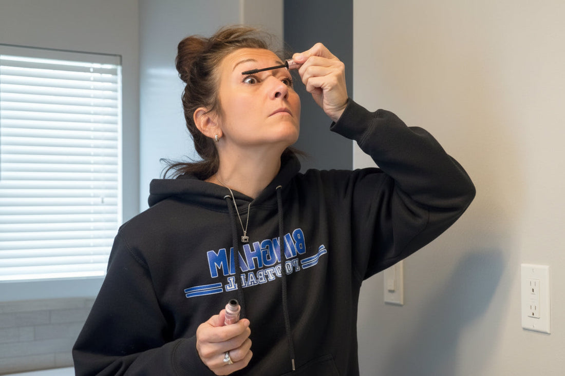 Woman applying mascara in a mirror